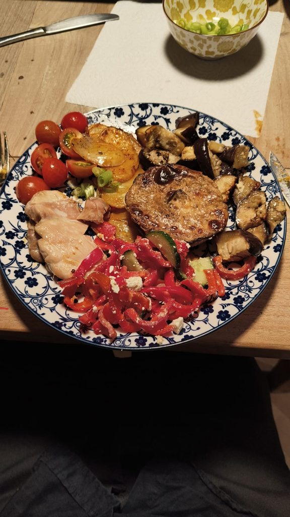 Bord met kip, aubergine, aardappelschijfjes, gevulde portobello en paprikasalade met feta